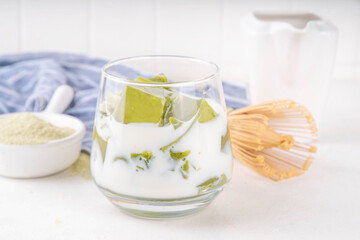Matcha jelly latte, iced milky drink with green matcha tea jellatin cubes, trendy refreshing Iced non-caffeine healthy drink