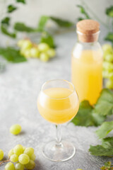 Traditional Czech low alcohol new white wine Burcak in wineglasses with grapes bunches