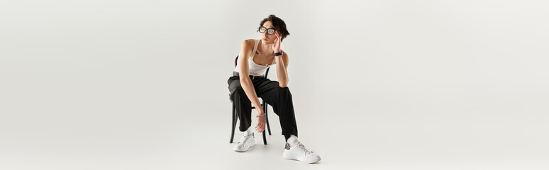 Stylish young man poses effortlessly in studio showcasing modern fashion trends