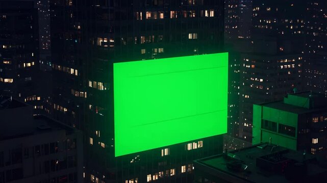 green screen tron video mockup display on top of skyscraper building at night