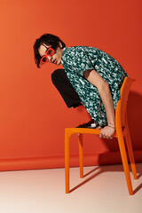 Slim young man rocks trendy summer outfit in vibrant studio setting