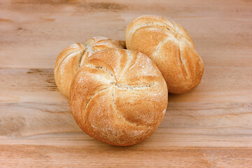 three buns on a wooden surface