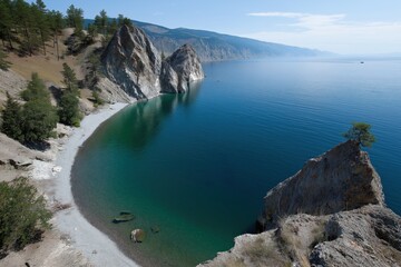 Obraz premium A rocky shoreline with a body of water in the background. The water is a deep blue color