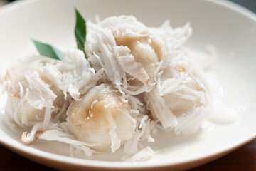 Tradition Thai dessert, Local name Kanom Tom, boiled rice flour dumpling coated with shedded coconut and filled with coconut melted in palm sugar.