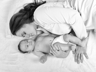 Young mother and her baby in bed. Mother and baby. Happy family.