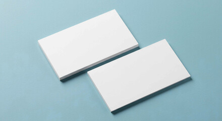 Two blank white business cards on a light blue background, perfect for showcasing your brand identity or design.	