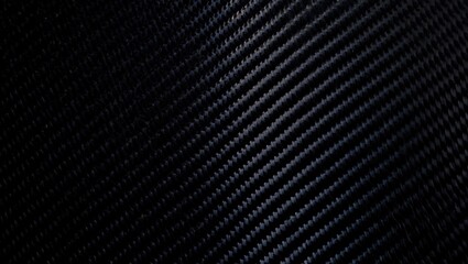 Textured carbon fiber surface with diagonal weave pattern in dark tones