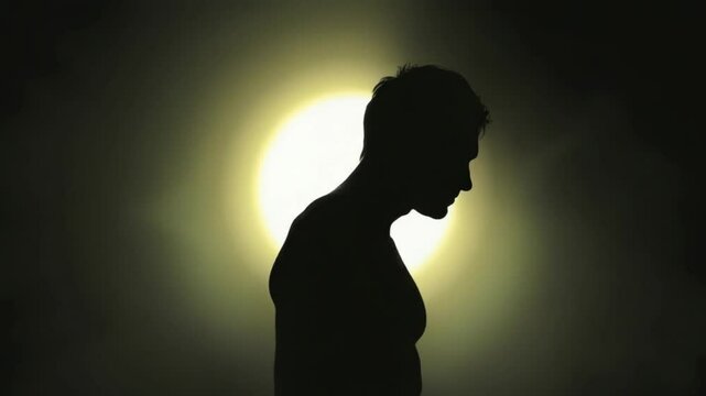 Silhouette man illuminated by light
