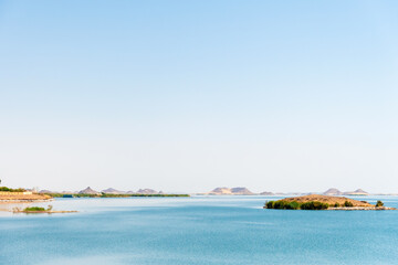 Serene panoramic landscape view of a Egyptian Nasser lake, showcasing its clear blue waters, small islands and distant desert mountains