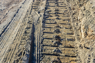Construction equipment tracks in the sand.
