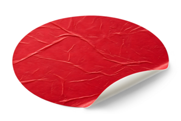 A close-up of a round red paper sticker with a slightly rough and textured surface on transparent or white background