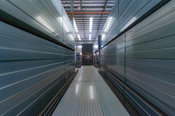 The aluminum products piled up in the warehouse of the aluminum factory, shining brightly under the light, form beautiful patterns