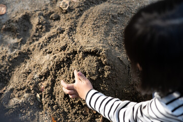 砂場で遊ぶ子供の手