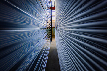 The aluminum products piled up in the warehouse of the aluminum factory, shining brightly under the light, form beautiful patterns