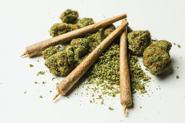 Close up of marijuana joint and buds on white background.