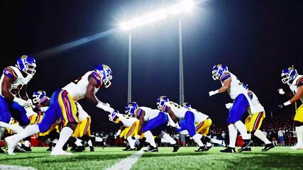 Gridiron Football Line of Scrimmage Standoff Between Two Diverse Teams Under Stadium Lights. Intense Moment of the Start of the Professional American Football Game, Players in Action During a Match - Powered by Adobe