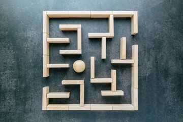 A wooden ball stuck in a maze game made of pieces of wood, top view, a situation where no way out...