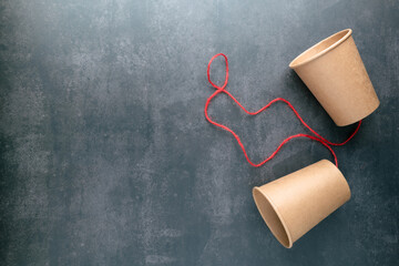 Old style brown cup phone with red string, toy phone, two-way communication concept