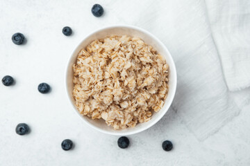 Delicious oatmeal topped with fresh blueberries on a clean surface