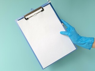Hand in blue protective glove holding blank tablet