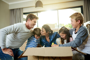 Bonding, boxes and family packing in new home with sorting items for donation, charity or community. Cardboard, love and parents helping children sort household supplies for moving in house.