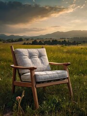 A chair positioned in a grassy field with a mountain range visible in the background under a clear blue sky