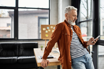 Casual professional engaged with smartphone in a modern office environment during daytime