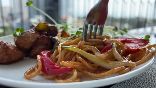 lunch pasta with tomatoes sweet pepper meat and vegetables twist with a fork delicious spaghetti close-up