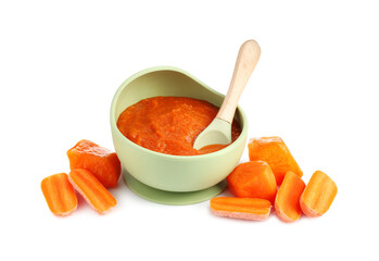 Baby food. Tasty puree in bowl, spoon, carrot and persimmon isolated on white