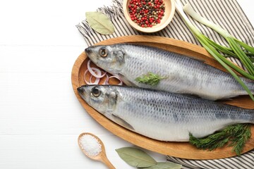 Salted herrings and spices on white wooden table, flat lay. Space for text