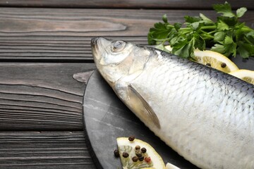 Salted herring and spices on wooden table, closeup. Space for text