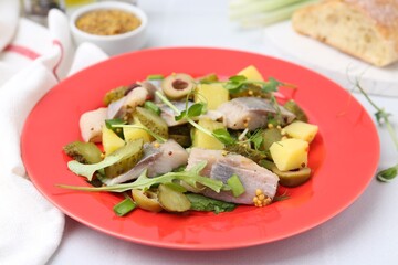 Delicious salad with herring on white tiled table, closeup