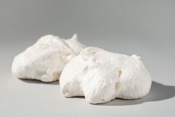 Delicious homemade meringue cookies on gray background, closeup