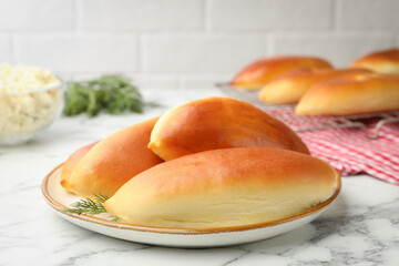 Tasty baked patties on white marble table, closeup