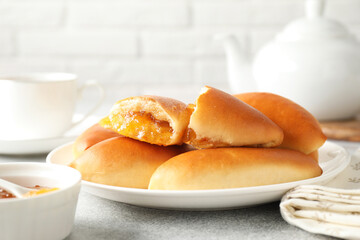 Tasty baked patties with orange jam on light grey table, closeup