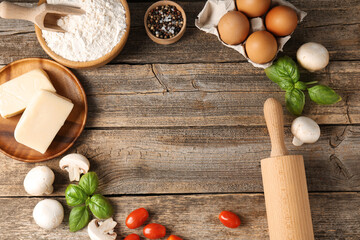 Making pizza. Different ingredients on wooden table, flat lay. Space for text