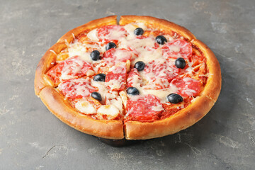 Tasty pizza with salami, cheese and olives on grey table, closeup
