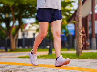 Fit leg woman asian jogging workout on street in the park, focus to healthy and wellness. Close up...