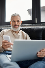 Confident man engaged in multitasking at a modern office workstation during daytime hours