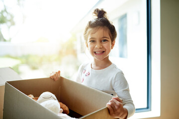 Box, portrait and smile of girl in new home on moving day, excited for child development or growth....
