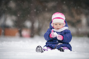 Baby girl playing with snow for the first time