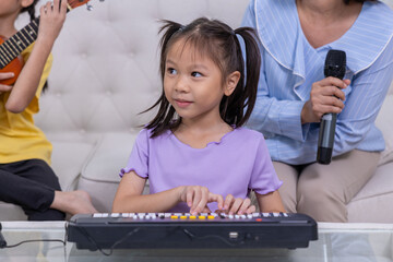 Happy family, mother and daughter are having fun playing music and singing