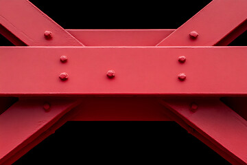 Bold red structure with riveted beams. Structural art with geometric precision. Strong red beams intersect in an industrial construction detail.