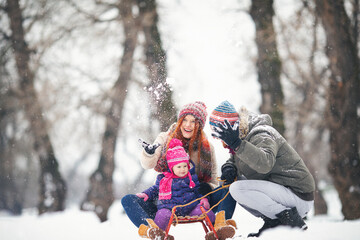 Young family with baby girl outdoors having fun in the snow. Shallow DOF. Developed from RAW;...