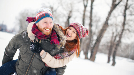 Obraz premium Young family with baby girl outdoors having fun in the snow. Shallow DOF. Developed from RAW; retouched with special care and attention; Small amount of grain added for best final impression.