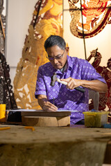 Craftsmen create traditional Thai Khon puppets.