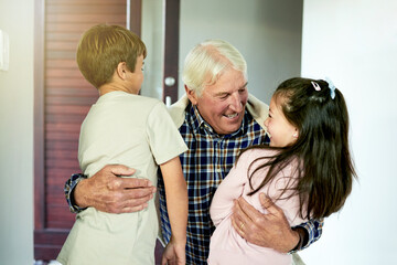 Fototapeta premium Kids, smile and hugging grandfather for visit in home with arrival welcome, greeting and reunion. Excited people, family connection and embrace by front door with bonding together and relationship
