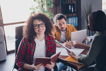 Smiling young professionals collaborating in a modern office space during a daytime meeting