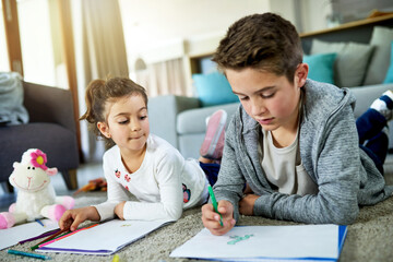 Naklejka premium Kids, siblings and coloring homework in home, books and artistic activity for creative education. Children, drawing together and bonding on floor of living room, support and learning lesson for skill