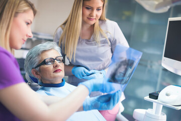 Dentist showing xray image to a senior patient